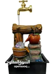  1 نافورة ديكور خشبية وفخارية بتصميم فاخر  حنفية ذهبية أنيقة يتدفق منها الماء بانسيابية. قاعدة خشبية