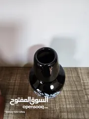  7 فازة مزهرية سوداء مزخرفة باللون الذهبي مع باقة ورد