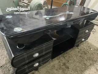  1 طاولة شاشة قزاز سكريت مع اربع جوارير لون اسود ثقيلة مافيها كسر طاوله