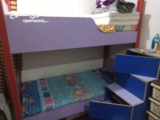  1 سرير أطفال طابقين مع درج فيه كبتات