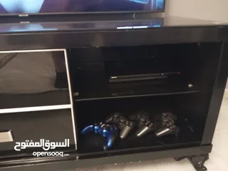  10 طاولة تلفزيون لون اسون بحالة ممتازة للبيع درجين وسطانيات واماكن تخزين جانبية  سطح زجاجي وارفف زجاجية
