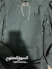  3 فستان زيتي للمحجبات – فيونكة جانبية بخرز فضي (قماش شبيه بالساتان)