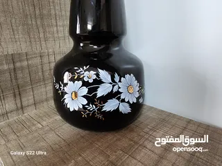  8 فازة مزهرية سوداء مزخرفة باللون الذهبي مع باقة ورد