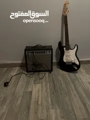  1 Electric guitar(Black and white) and Amplifier.  غيتار كهربائي(اسود و ابيض) و مكبر للصوت