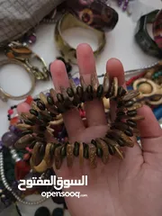  9 أساور خشب وواحدة حديد (بني أزرق ملون)