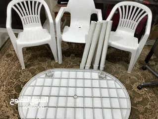  4 طاولة بلاستيك مع ثلاثة كراسي ومظلة