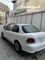  2 اكسنت 97 لون ابيض فيها ضربه بالجناح