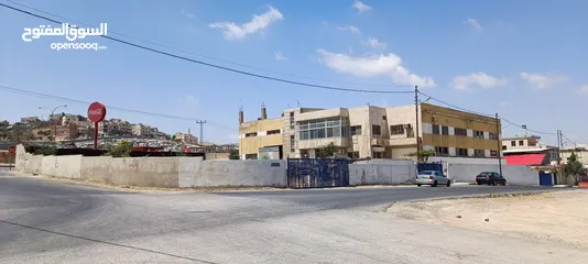  1 مبنى وأرض فارغة ملاصقة للمبنى/ محول كهرباء 1500 أمبير/موقع مميز على طريق الحزام خلف مطار ماركا