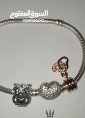  9 PANDORA sliver bracelet with heart shaped clasp with some charmsاسواة باندورا فضة بشكل قلب مع إضافات