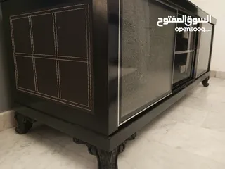  7 طاولة تلفزيون لون اسون بحالة ممتازة للبيع درجين وسطانيات واماكن تخزين جانبية  سطح زجاجي وارفف زجاجية