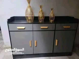 1 خزانة بتصميم راقٍ يجمع بين العملية والجمال، بلون رمادي أنيق ولمسات سوداء، مع مقابض ذهبية تضيف فخام