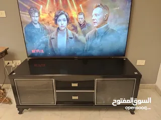  2 طاولة تلفزيون لون اسون بحالة ممتازة للبيع درجين وسطانيات واماكن تخزين جانبية  سطح زجاجي وارفف زجاجية