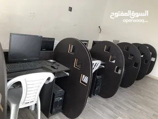  2 اجهزة كمبيوتر مع طاولات وكراسي