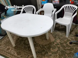  1 طاولة بلاستيك مع ثلاثة كراسي ومظلة