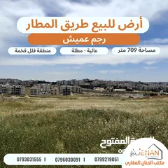  1 أرض للبيع طريق المطار رجم عميش مساحة 709 متر تنظيم سكن خاص طابقين وروف عالية مطلة على شارع المطار بس