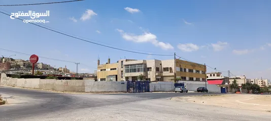  4 مبنى وأرض فارغة ملاصقة للمبنى/ محول كهرباء 1500 أمبير/موقع مميز على طريق الحزام خلف مطار ماركا