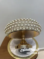  2 تحف منزليه باللون الذهبي على شكل دائري مزينه بالؤلؤ  ويمكن استخدامها للضيافه او تزيينها بالورود