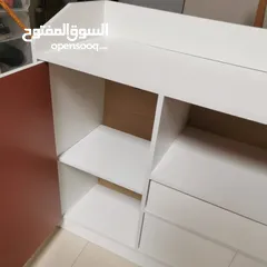  12 خزانة عملية مع مقابض خشبية بسيطة وأنيقة  تصميمها يجمع بين المساحات المغلقة والرفوف المفتوحة لسهولة
