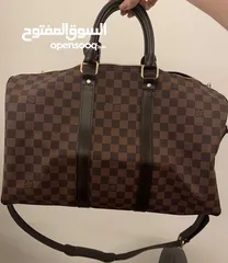  1 Louis Vuitton Keepall Bandoulière 50 - Timeless Elegance with a Pop of Red