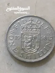  2 تُظهر الصورة عملة شلن بريطانية تعود لعام 1958.   كان الشلن البريطاني، الذي يُختصر بـ "1s" أو "1/-"،