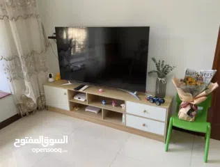  3 خزانة مزنزن تلفزيون خشبية عصرية   تصميم أنيق يجمع بين الخشب الطبيعي والأبواب البيضاء ليضيف لمسة