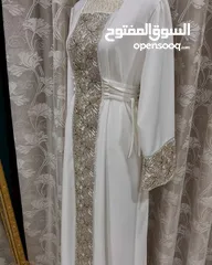  6 أناقة تليق بكِ  فستان نسائي فاخر بلون أبيض ملكي ولمسات تطريز فخمة بالذهبي اللامع.