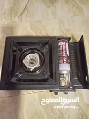  1 موقد للطبخ مستعمل مرتين فقط يعمل ب علبة غاز صغيرة على جانبه