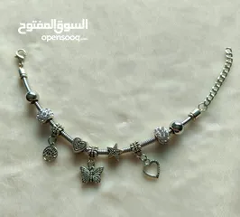  1 اسوارة ستيل لون فضي مع تعليقات ستيل متنوعة ومرصّعة