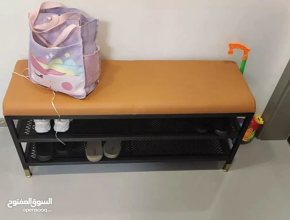 كرسي مريح مع مقعد مبطّن باللون البرتقالي  وإطار معدني قوي باللون الأسود