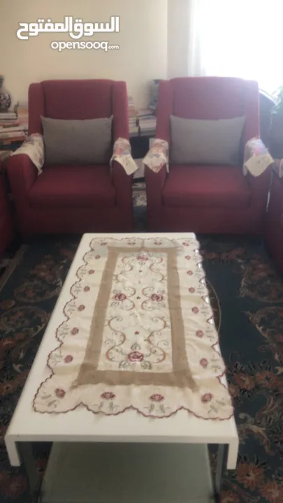 طقم كنب لون احمر و طاولات ستان ستيل و زجاج