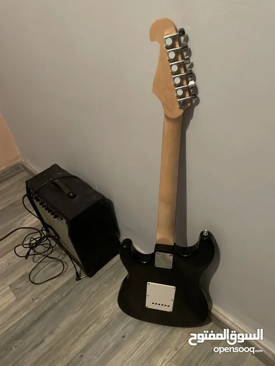 Electric guitar(Black and white) and Amplifier.  غيتار كهربائي(اسود و ابيض) و مكبر للصوت