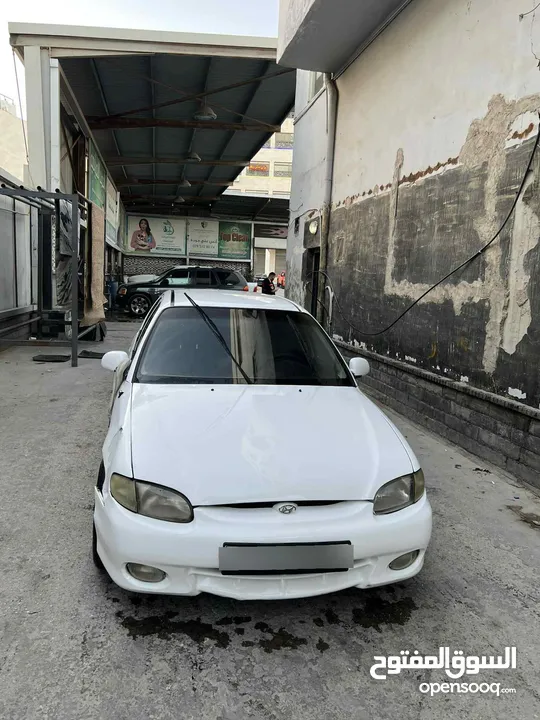 اكسنت 97 لون ابيض فيها ضربه بالجناح