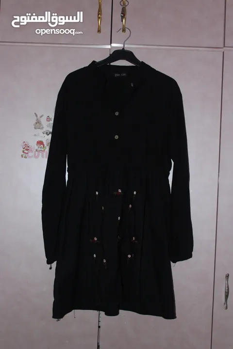 فستان نسائي قصير بقصة واسعة على الخصر، بلون أسود سادة، ومطرز بالورود