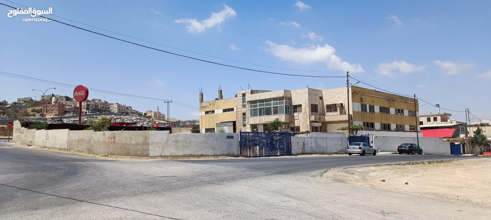 مبنى وأرض فارغة ملاصقة للمبنى/ محول كهرباء 1500 أمبير/موقع مميز على طريق الحزام خلف مطار ماركا