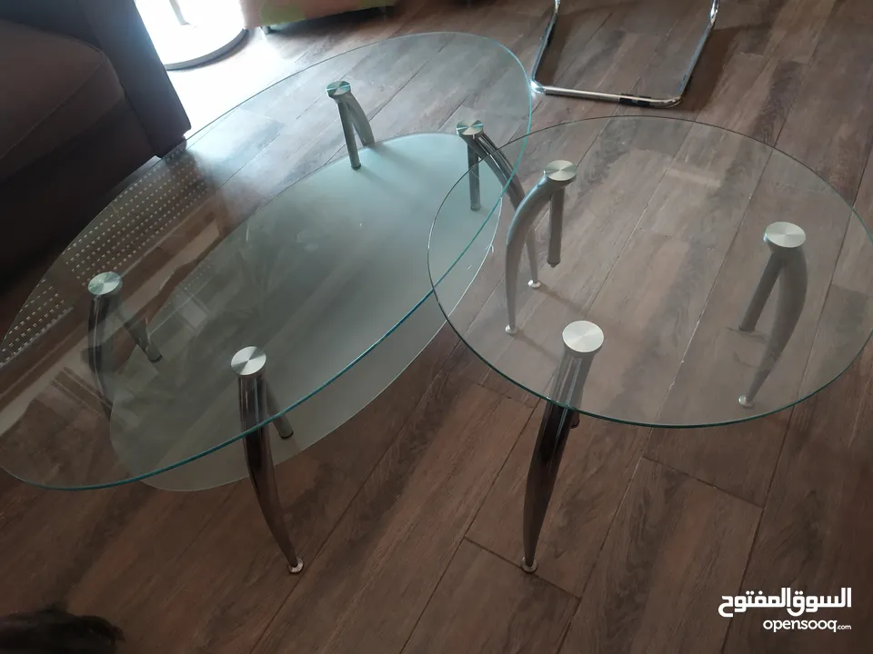 طاولة زجاج وكراسي خشب ولوحات