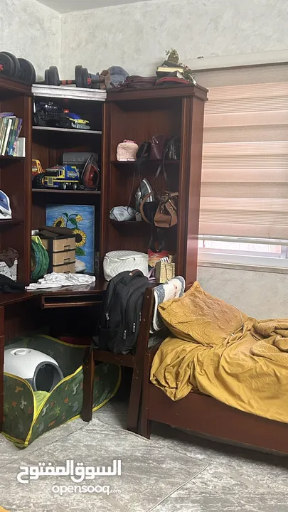 غرفة نوم مكونة من تختين وخزانة ومكتبة
