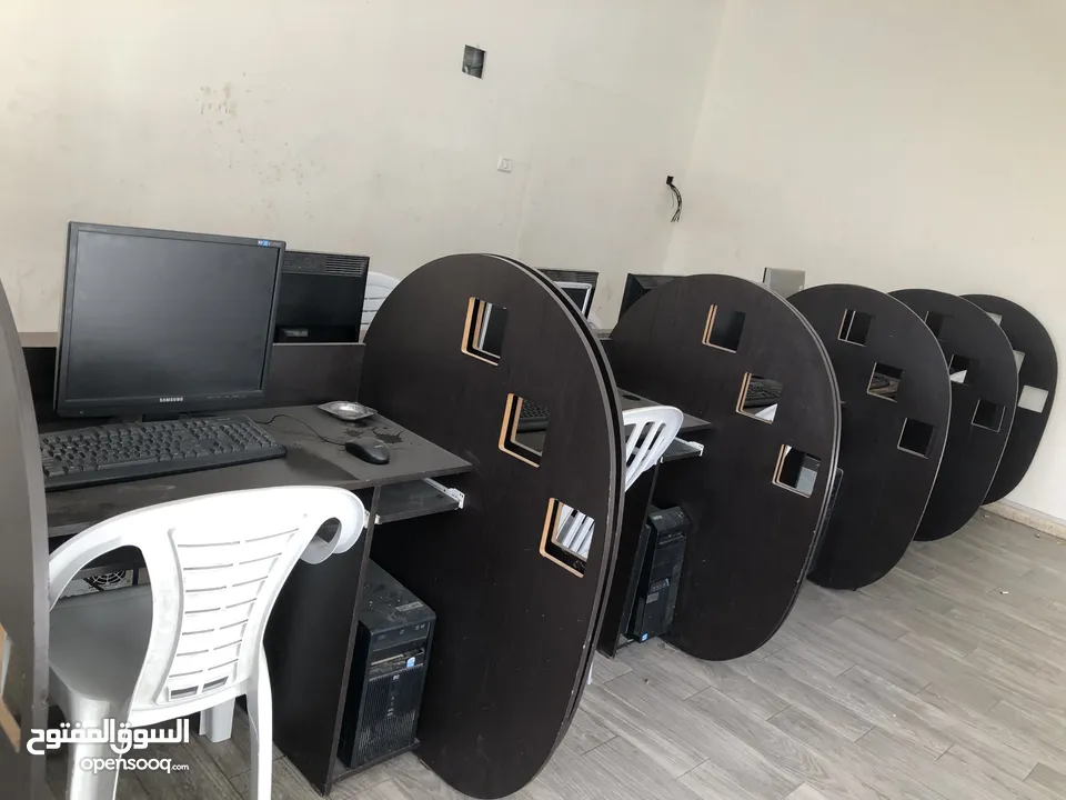 اجهزة كمبيوتر مع طاولات وكراسي