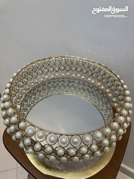 تحف منزليه باللون الذهبي على شكل دائري مزينه بالؤلؤ  ويمكن استخدامها للضيافه او تزيينها بالورود