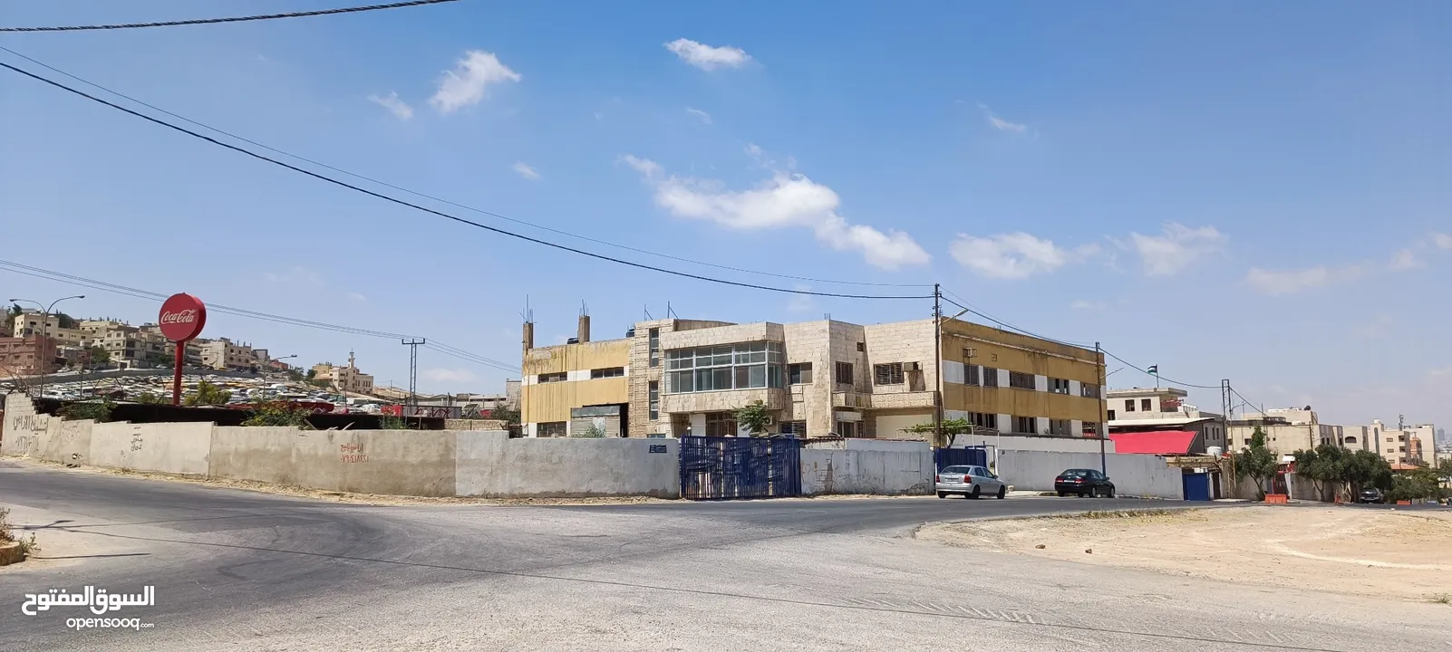 مبنى وأرض فارغة ملاصقة للمبنى/ محول كهرباء 1500 أمبير/موقع مميز على طريق الحزام خلف مطار ماركا