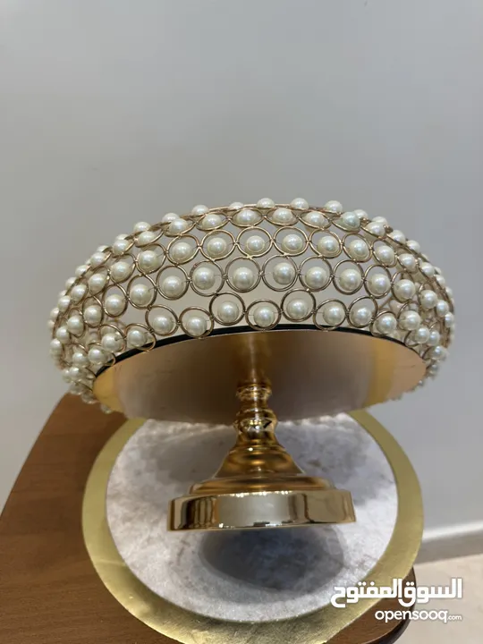 تحف منزليه باللون الذهبي على شكل دائري مزينه بالؤلؤ  ويمكن استخدامها للضيافه او تزيينها بالورود