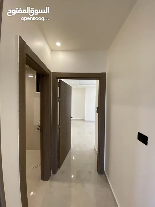 شقة طابق اخير مع روف 230 متر وتراس 100 متر على شارعين  طريق المطار خلف المدارس العالمية بسعر مميز