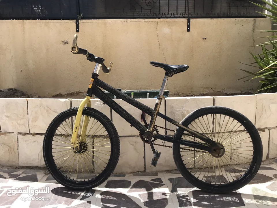 دراجة سوداء وذهبية بالكاد تستخدم في حالة جيدة جنت 20 نظيفة ومزينة بالملصقات Black and gold bicycle