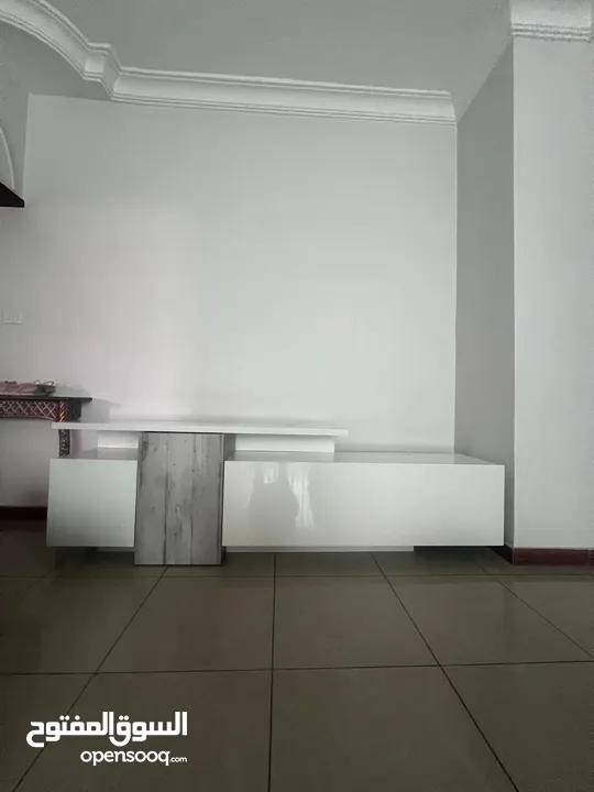 طاولة تلفزيون لامنيت لون ابيض بحالة الجديد مع وحدات تخزين
