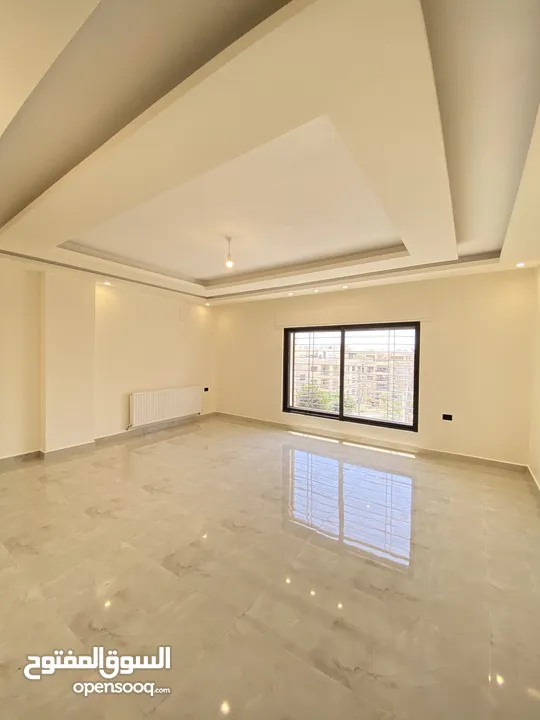 شقة طابق اخير مع روف 230 متر وتراس 100 متر على شارعين  طريق المطار خلف المدارس العالمية بسعر مميز