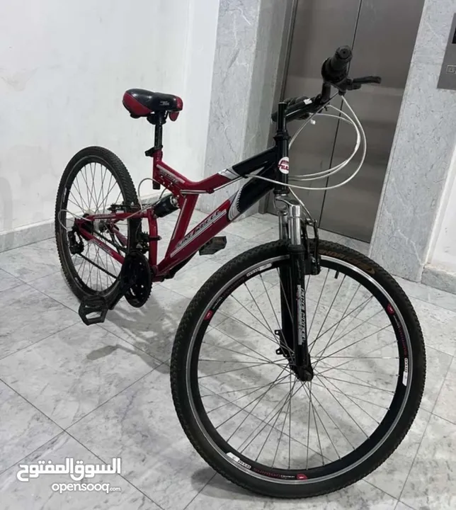 two bicycles Full-suspension mountain bike with a 27 red and black