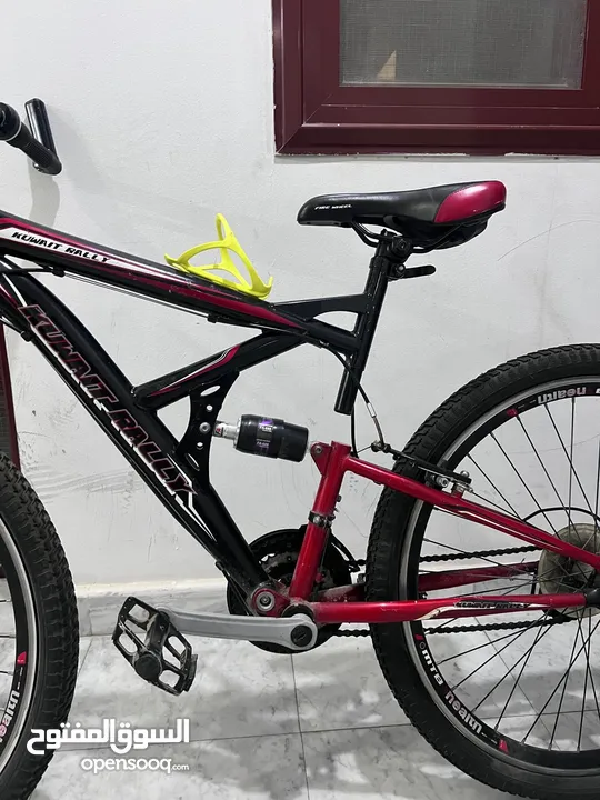 two bicycles Full-suspension mountain bike with a 27 red and black