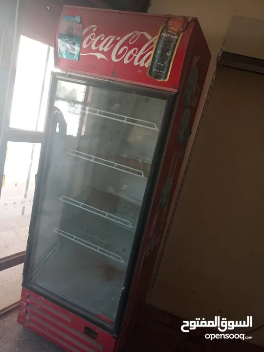 رفوف وثلاجة كولا. بضاعة سوبر ماركت
