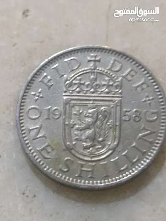 تُظهر الصورة عملة شلن بريطانية تعود لعام 1958.   كان الشلن البريطاني، الذي يُختصر بـ "1s" أو "1/-"،