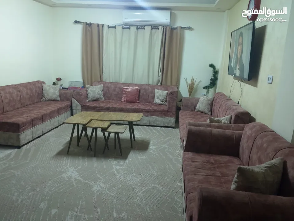 كنب مع طاولات وبرداي وسجادة