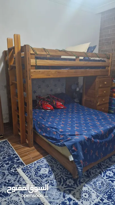 غرف نوم مكونة من تخت حجمه مفرد ونصف خزانة خشبية وكنبة ثلاثية الشكل